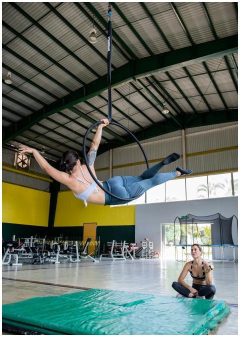 A woman performs aerial acrobatics on a hoop in a