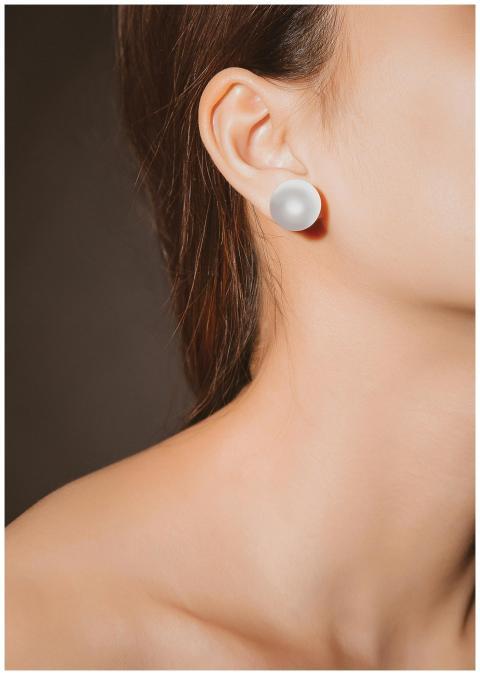 A close-up of an elegant pearl earring on a woman'