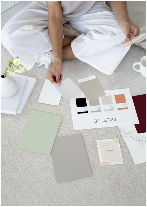 Designer sits on carpet with color palettes and sa