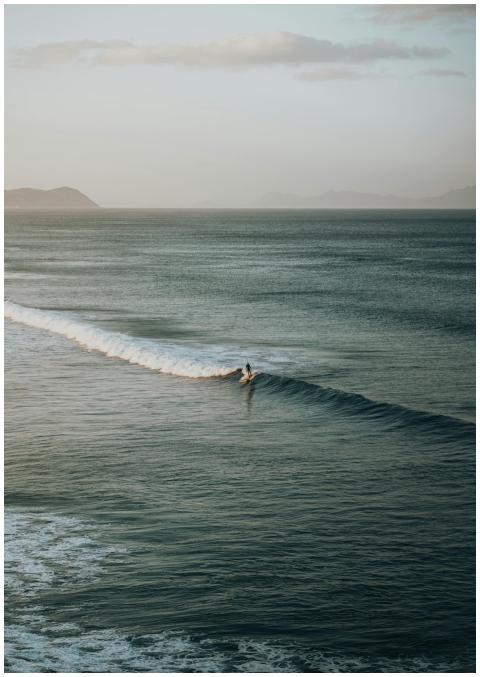 Surfer riding waves in serene ocean setting, captu