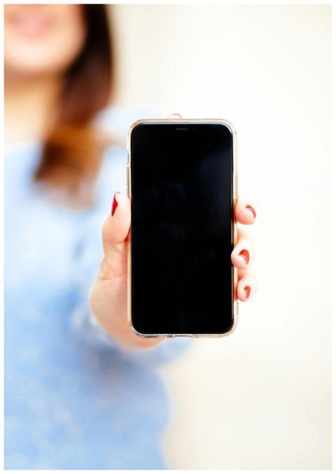 Close-up of a smartphone held by a woman in a New