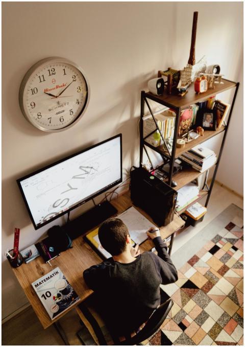 A student focused on studying at a home office des
