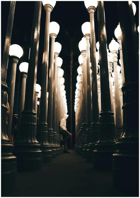 A solitary person walks through an illuminated pat