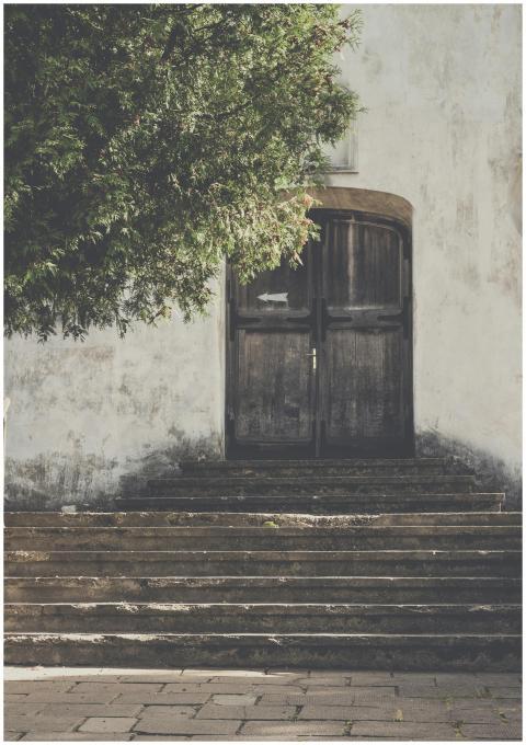 Weathered wooden doorway framed by stone steps and