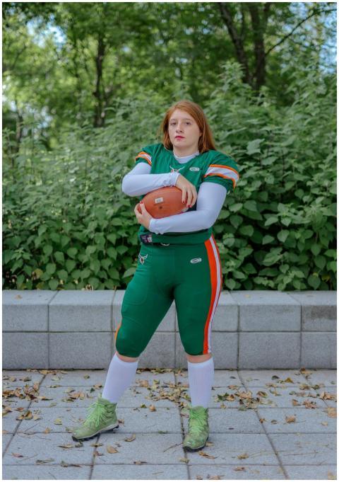 Young female American football player posing outdo