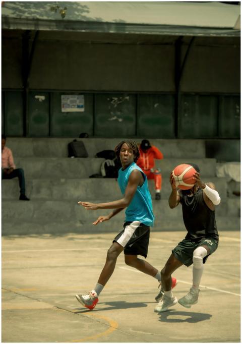 Two young men playing basketball on an outdoor cou