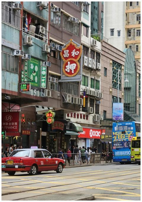 Bustling street in Hong Kong with a red taxi, doub