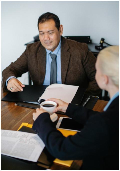 Two professionals in a meeting discussing document