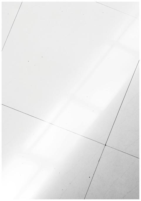 A white tiled floor with sunlight casting geometri