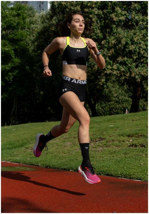 Young woman running on an outdoor track surrounded