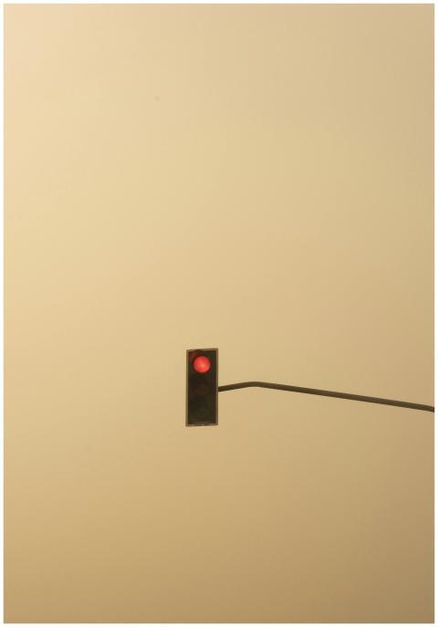 A solitary traffic light with red signal stands ou
