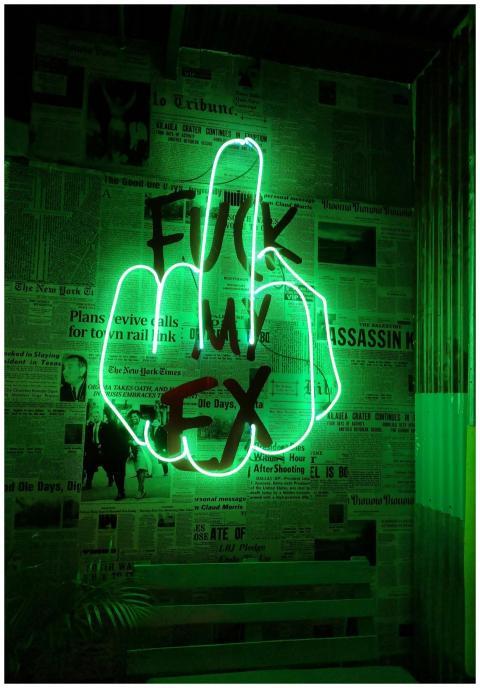 Illuminated green neon sign with bold lettering ag