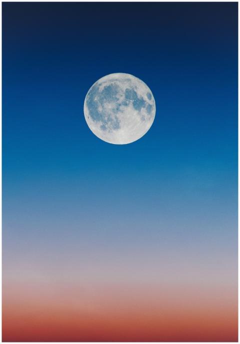 A serene full moon set against a gradient twilight