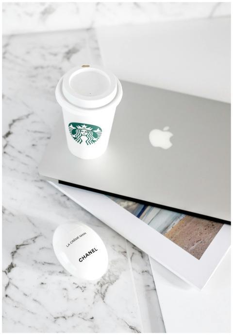 Minimalist workspace featuring a laptop, coffee cu