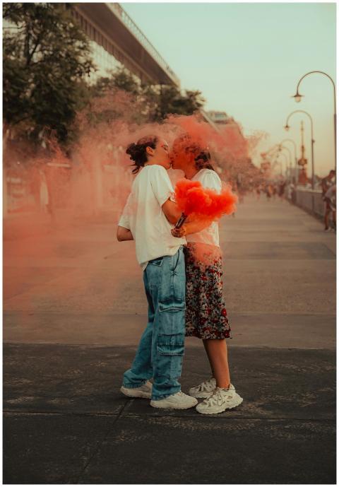 A joyful couple embracing amidst vibrant orange sm
