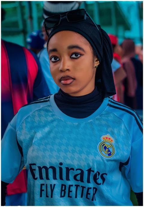 Young woman in Real Madrid jersey, headscarf, and