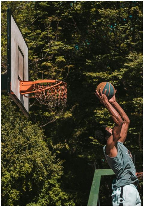 Athlete performs an impressive slam dunk on an out