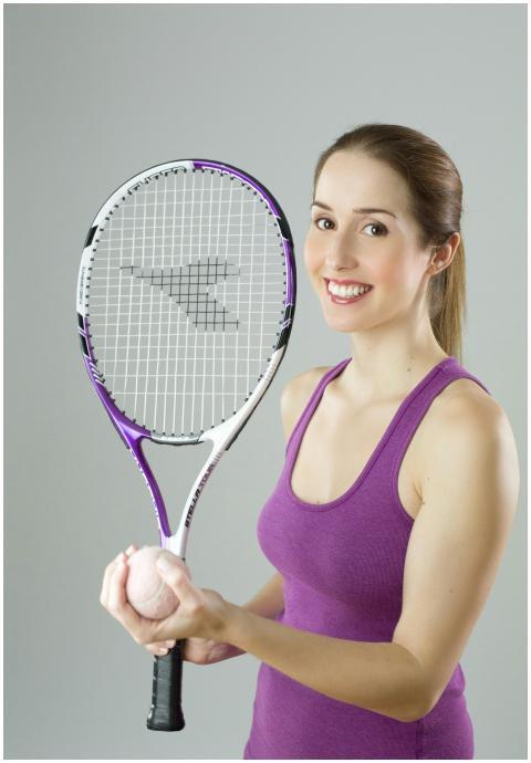 Smiling female tennis player holding a racket and
