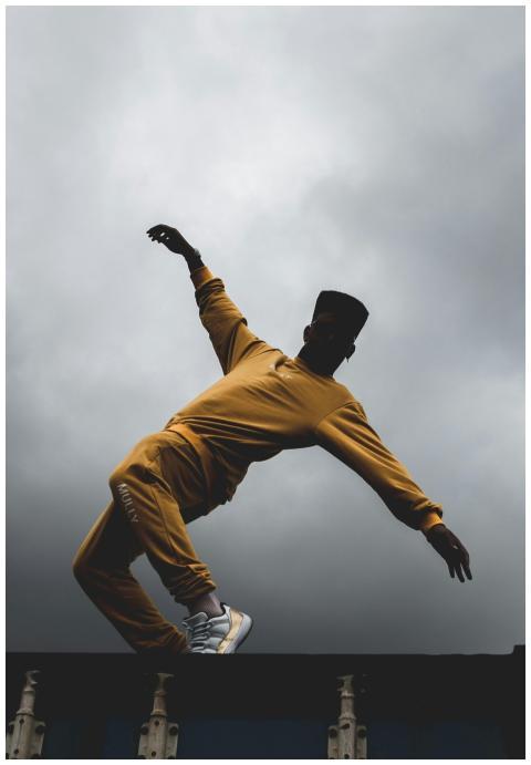 A dancer in vibrant yellow attire executes a dynam