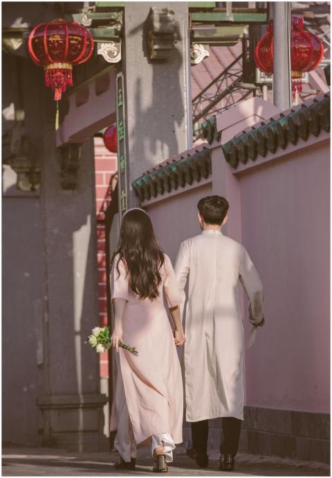Couple in traditional attire walking along a decor