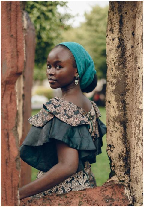 Nigerian woman in vibrant attire posing gracefully