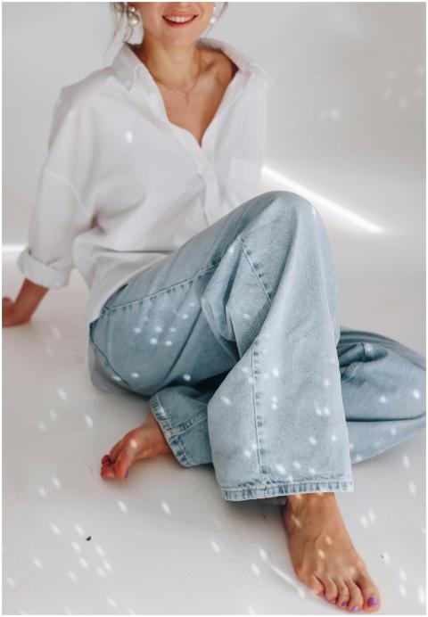 Woman in casual white blouse and jeans, sitting on
