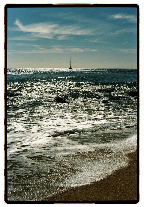 Tranquil beach scene with gentle waves and a dista
