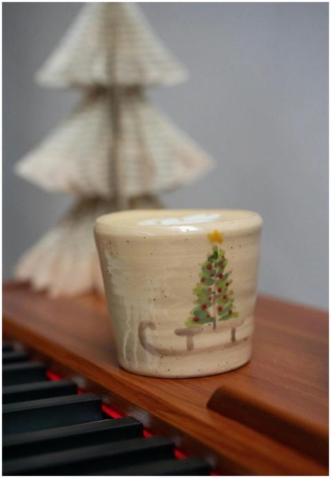 A festive ceramic mug featuring a Christmas tree d