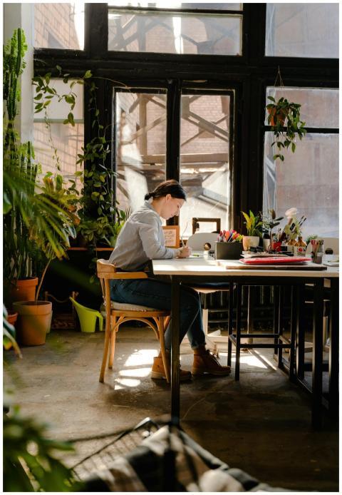 A female artist working diligently in a sunlit stu