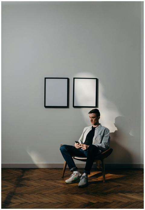 A man using a smartphone in a minimalist home offi