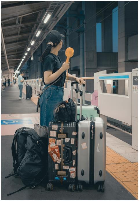 A traveler with suitcases waits at a Tokyo train s