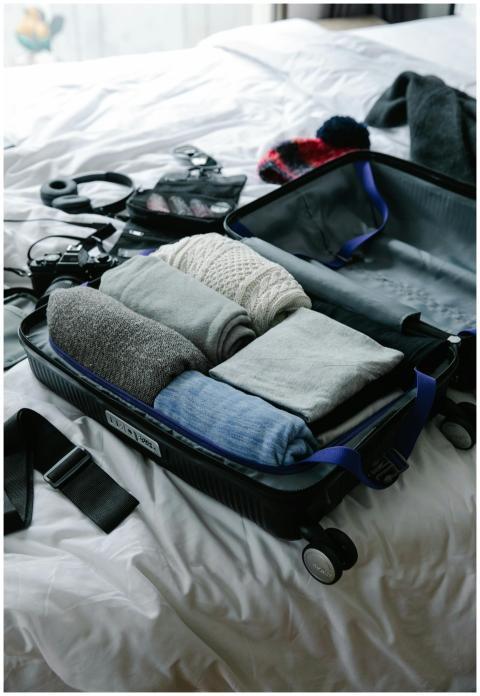 Open suitcase filled with neatly folded clothes on