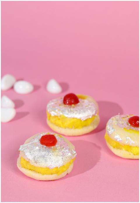 Three sweet pastries topped with icing and cherrie