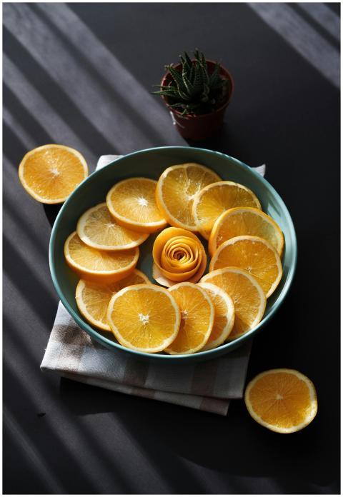 Bright and fresh orange slices in a sunlit bowl, p