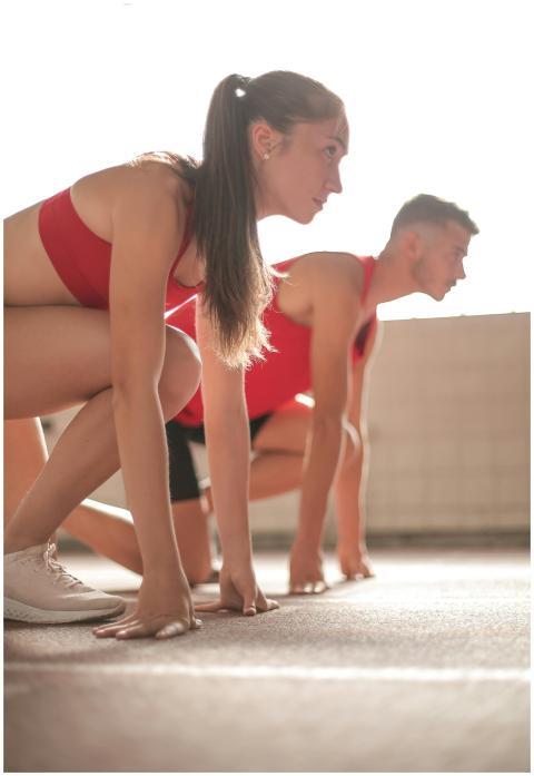 Two athletes crouched at the starting line indoors