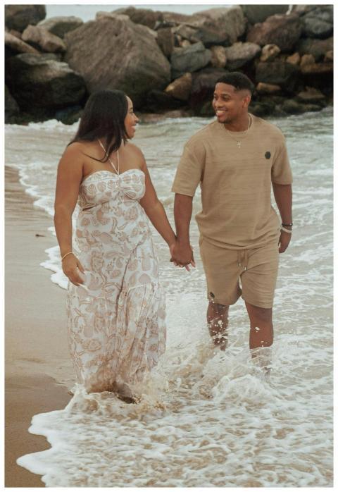 A joyful couple holding hands during a beach walk