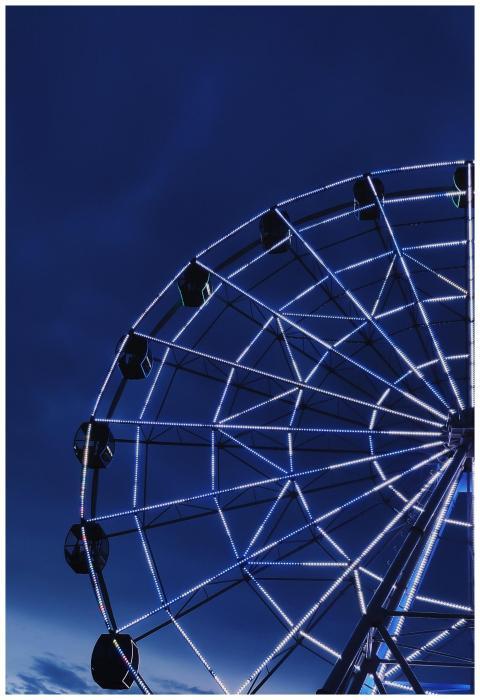 A bright Ferris wheel illuminated against a dark n