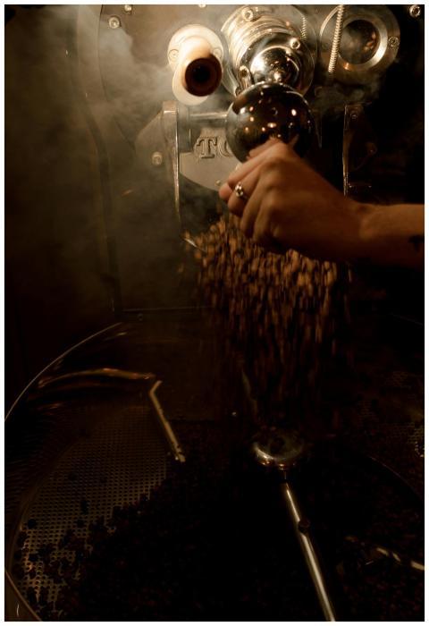 Close-up of a hand roasting coffee beans with rich