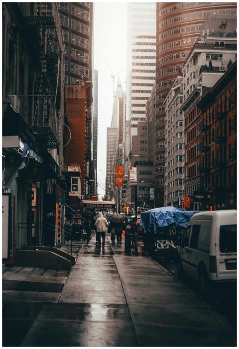 A busy New York City street in the rain with skysc