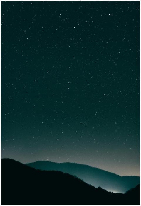 A scenic view of a starry night sky above serene m