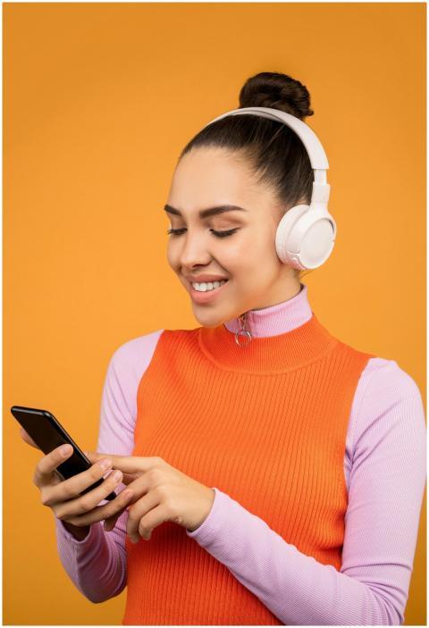 A woman in vibrant attire enjoying music on headph
