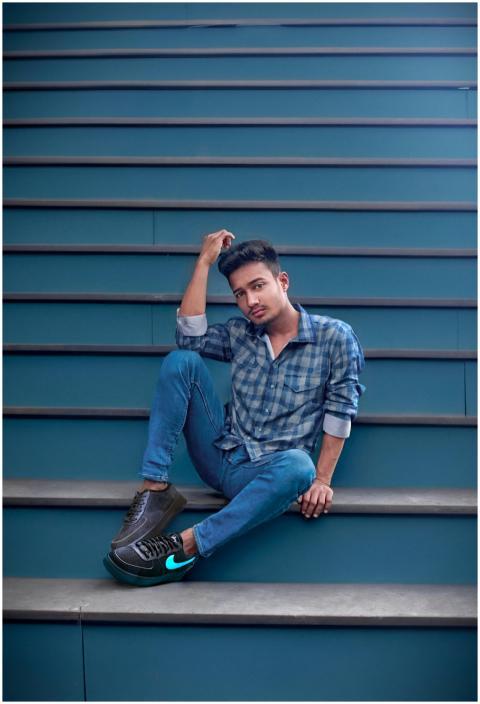 A man in stylish casual wear poses on an urban sta