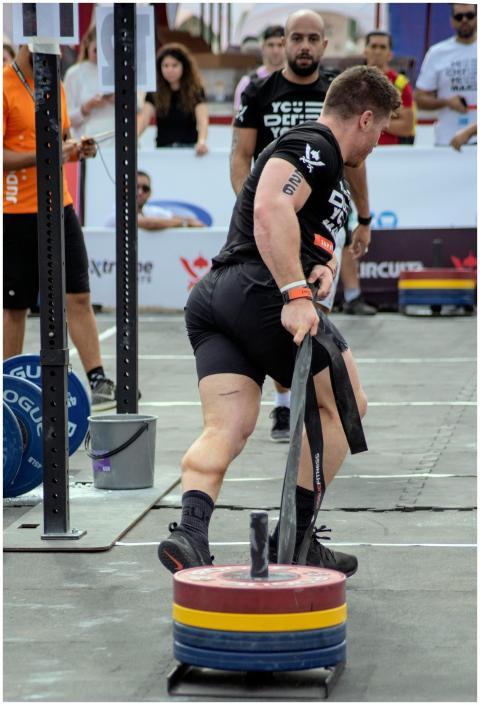 Athlete pulls heavy weights in a strongman competi