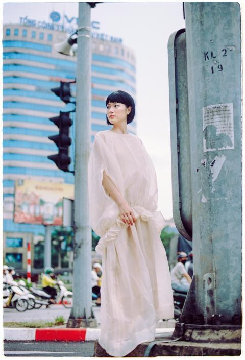 Stylish woman poses in a flowing sheer dress at a