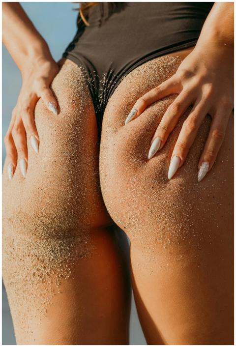 Close-up image of a woman's sand-covered skin in a