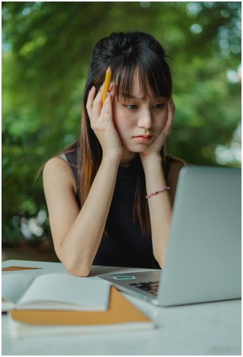 A young woman concentrated on her laptop while stu
