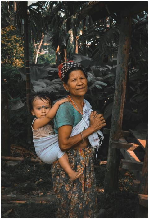 An Asian mother carries her baby in a traditional