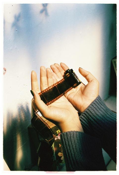 Close-up of hands holding a film strip, capturing