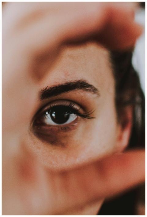 Artistic close-up of a woman's eye framed by her h