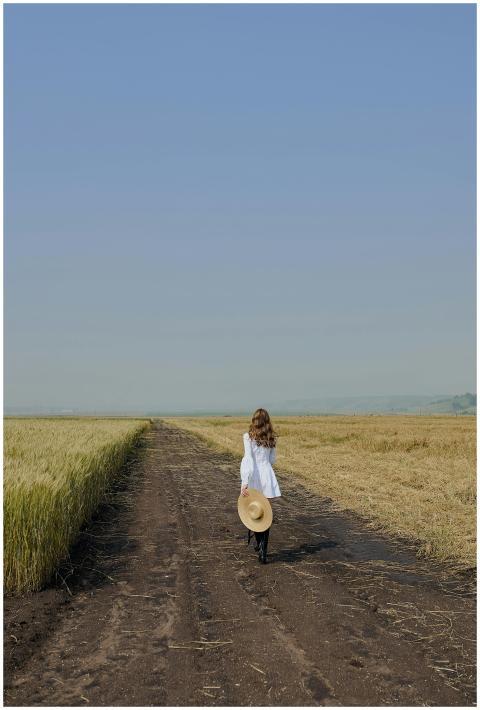 A woman in casual clothing walks along a rural pat